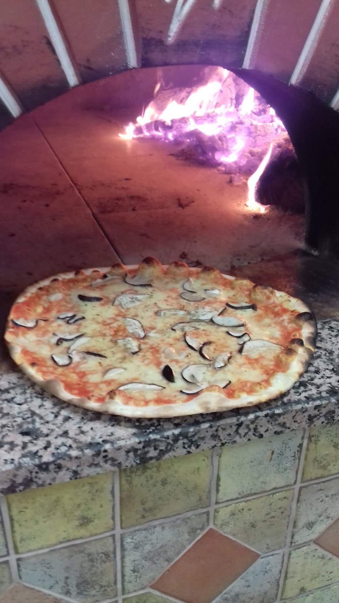 Pizza davanti al forno a legna