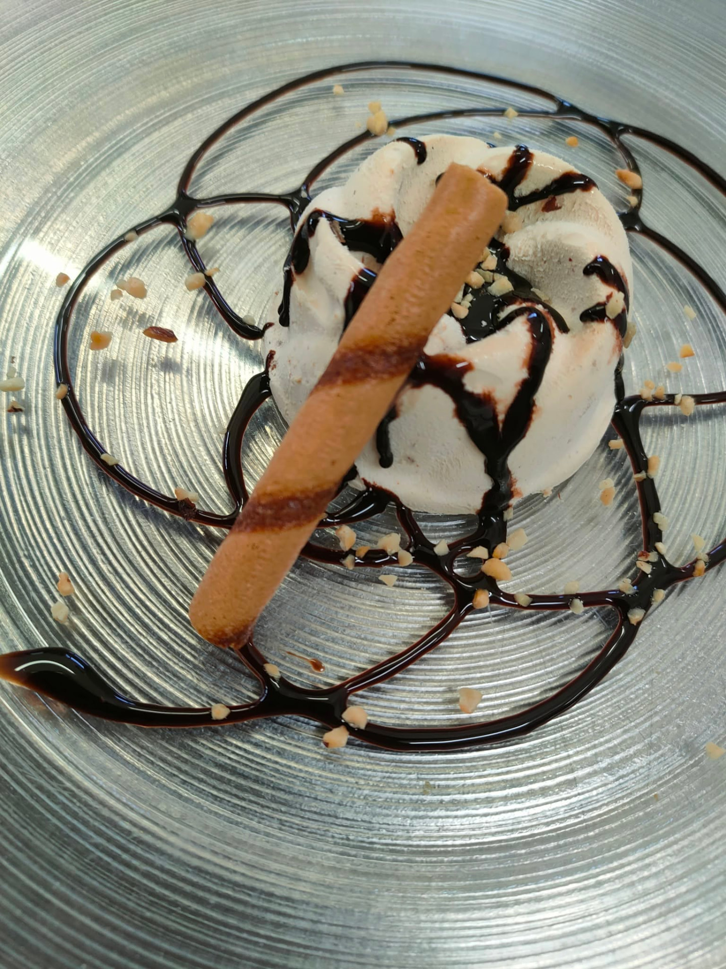 Dessert al piatto con crema, cioccolato e granella